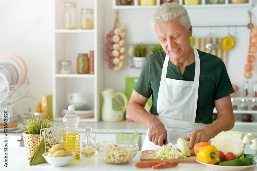 Portrait of elderly making salad at kitchen Portrait of elderly making salad at kitchen
