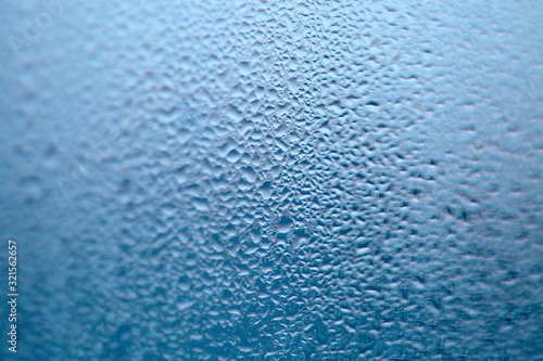 Drops of condensed steam, water drops. Close up detail of moisture condensation problems. Hot water vapor condensed on the cold window glass