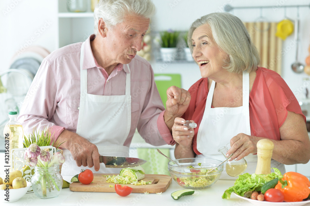 Portrait of senior couple cooking together at kitchen