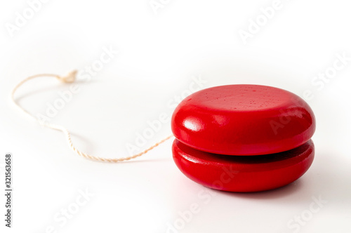 Childhood memories, nostalgia and vintage wood toy concept with red retro wooden yoyo isolated on white background