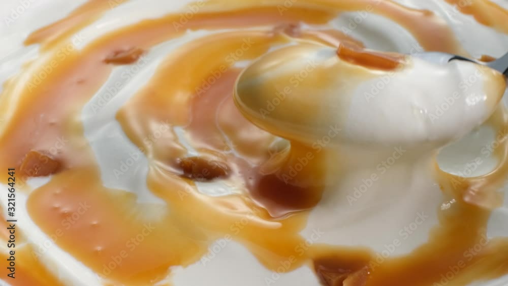 spoon of greek yogurt with melted caramel sauce spoon of greek yogurt with melted caramel sauce