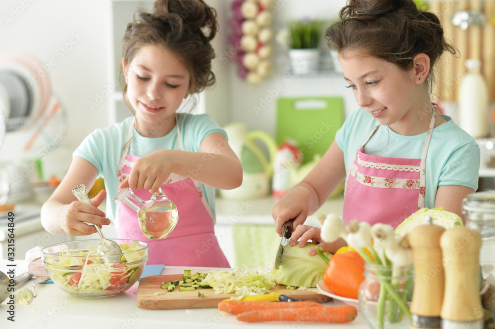 Portrait of girls preparing delicious fresh salad in kitchen Portrait of girls preparing delicious fresh salad in kitchen