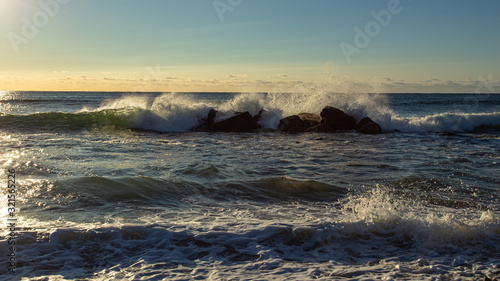 Waves breaking on rocks at sunrise at White Point Beach, Nova Scotia, Canada.