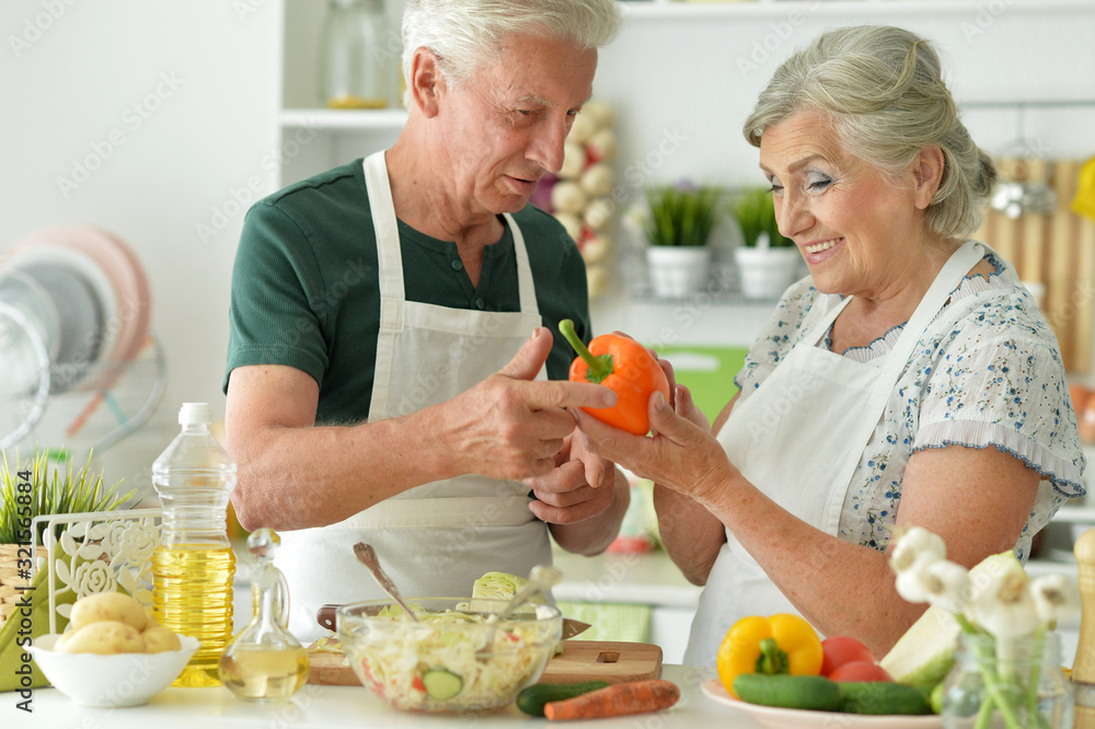 Portrait of senior couple cooking together at kitchen Portrait of senior couple cooking together at kitchen