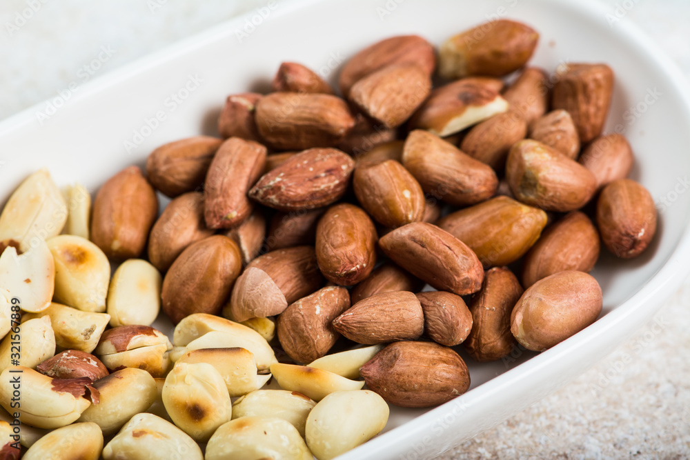 Peanuts in a white cup an old wooden floor. ramadan food. healthy nutrition. healthy food. vegetarian snack Peanuts in a white cup an old wooden floor. ramadan food. healthy nutrition. healthy food. vegetarian snack