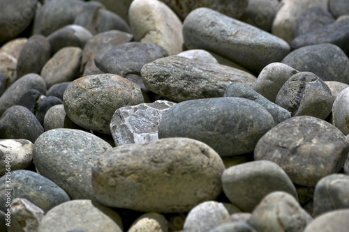 Different in shape and color gray beige rounded stones.