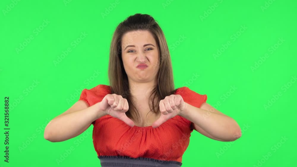 Portrait of cute girl showing thumbs down gesture. Green screen Portrait of cute girl showing thumbs down gesture. Green screen