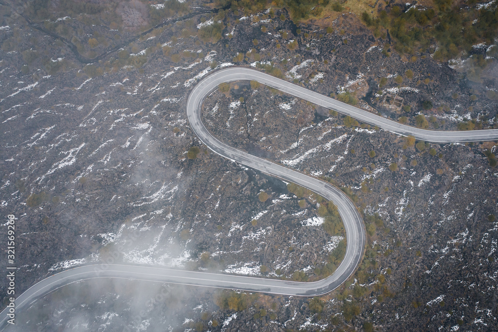 Scenic curvy road seen from a drone in autumn. Road view from above. Road in the lava rock. Road in Sicily, Italy