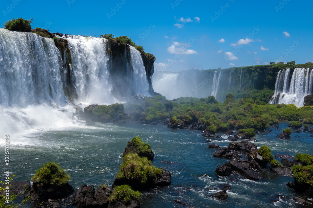 The awe inspiring Iguazu Falls (Iguaçu , waterfalls of the Iguazu River on the border between Argentina and Brazil. The largest waterfall in the world The awe inspiring Iguazu Falls (Iguaçu , waterfalls of the Iguazu River on the border between Argentina and Brazil. The largest waterfall in the world