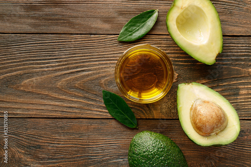 Avocado oil for healthy skin and hair on a wooden background.