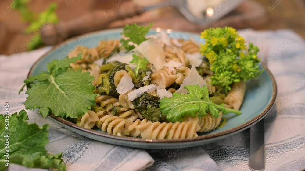 Cime di rapa pasta in a plate on with parmesan on a wooden table. Traditional food of the south of Italy, from Puglia Cime di rapa pasta in a plate on with parmesan on a wooden table. Traditional food of the south of Italy, from Puglia