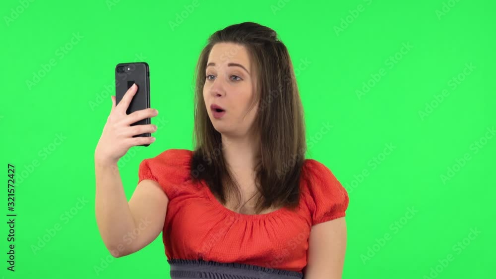 Portrait of cute girl talking for video chat using mobile phone and rejoice. Green screen Portrait of cute girl talking for video chat using mobile phone and rejoice. Green screen