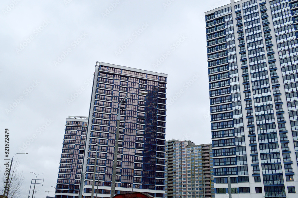 Fototapeta premium New modern tall blue glass multi-storey comfortable urban monolithic frame houses buildings skyscrapers new buildings in the big city of the megalopolis
