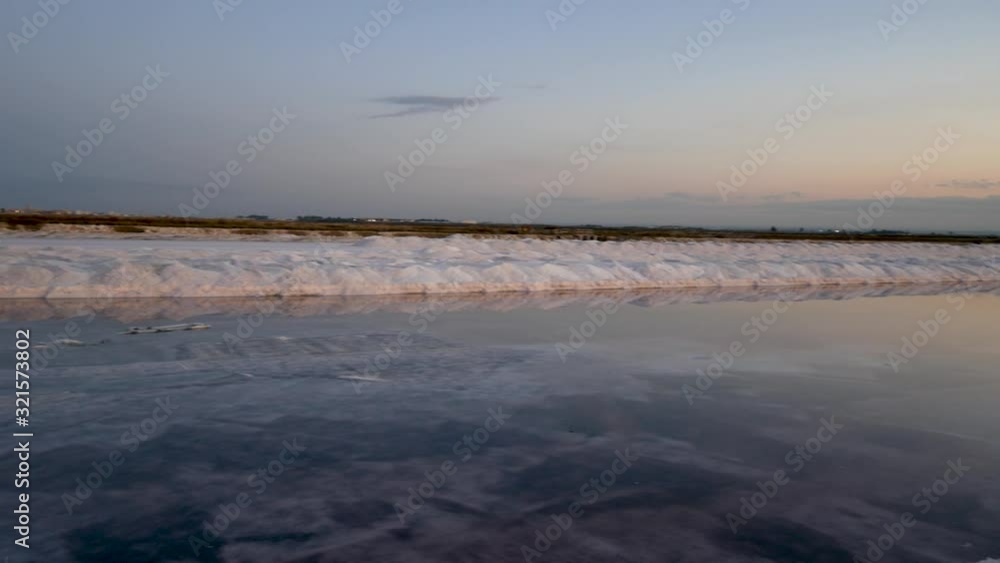 Nature reserve Saline Margherita di Savoia, Apulia, Italy: salt pan at sunset. salt flats area for sea salt production. A salt marsh, a coastal ecosystem on Adriatic sea. Nature reserve Saline Margherita di Savoia, Apulia, Italy: salt pan at sunset. salt flats area for sea salt production. A salt marsh, a coastal ecosystem on Adriatic sea.