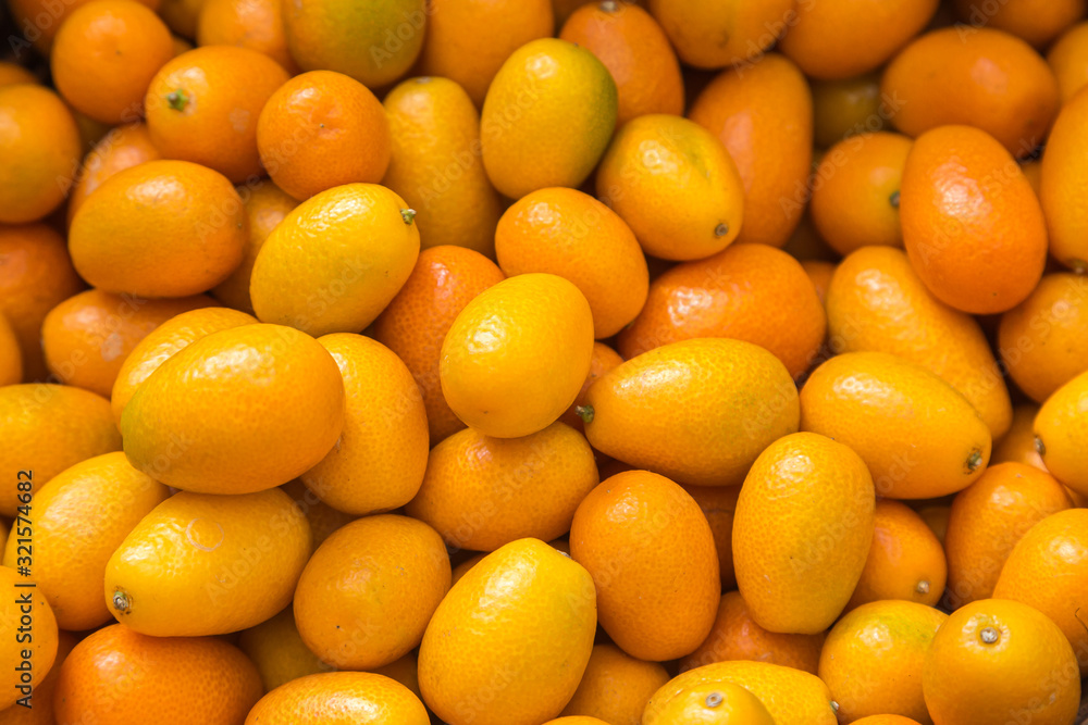 An abundance of kumquats for sale on a market stall An abundance of kumquats for sale on a market stall