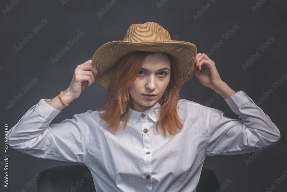 Red-haired girl in a hat on a dark background shows different emotions Red-haired girl in a hat on a dark background shows different emotions