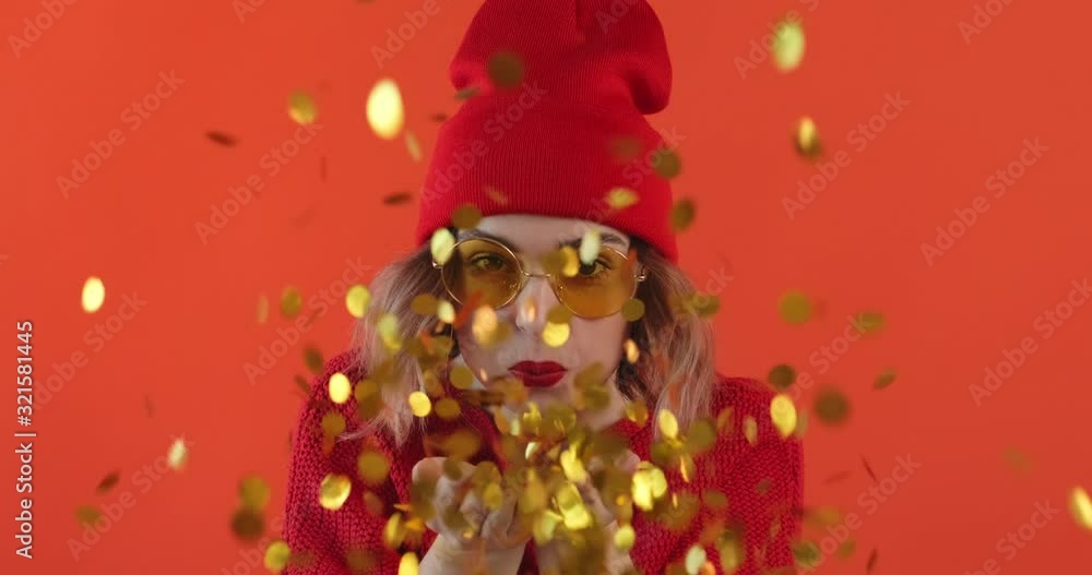 Portrait happy smile woman in star sunglasses inflates bubble from chewing gum balloon and bursts it in on blue background. Slow motion. Emotions of people. Lifestyle. Party. Monotone. Portrait happy smile woman in star sunglasses inflates bubble from chewing gum balloon and bursts it in on blue background. Slow motion. Emotions of people. Lifestyle. Party. Monotone.