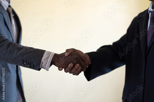 Fotografi Candid picture of Businessmen educating themselves with handshake showing happin