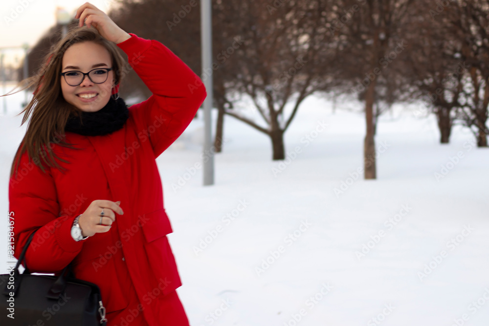 white girl in glasses and a red jacket. Against the background of snow and mountain ash.