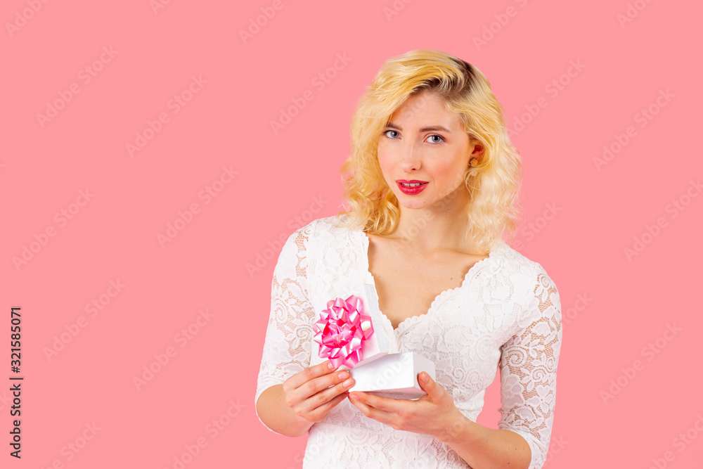 Portrait of young smiling woman opening a birthday, anniversary or valentineÕs day romantic gift Portrait of young smiling woman opening a birthday, anniversary or valentineÕs day romantic gift