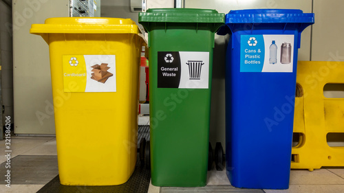 Yellow green and blue recycle wheelie bins in a plant room
