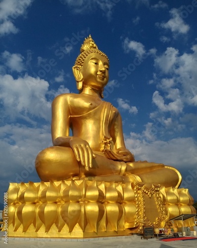 Big golden buddha statue  couldy sky. Norhern Thailand