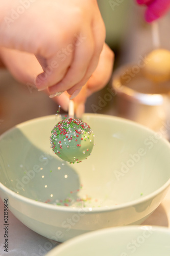 Moderne Cakepops mit Schokolade / Cany Melts überzug dekoriert mit Zuckerstreusel Kuchen am Stiel Fondant Dekoration photo