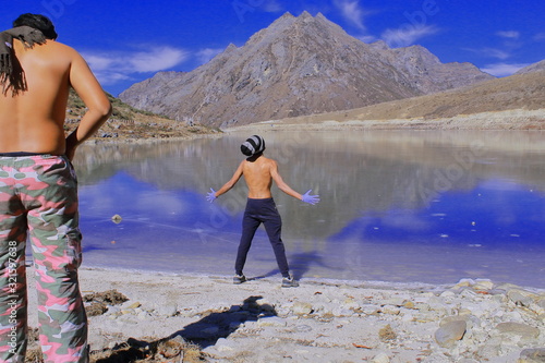 tourists are enjoying the view of beautiful frozen sela lake, surrounded by high himalaya and unspoiled nature. high altitude sela lake located in tawang district, arunachal pradesh in india photo