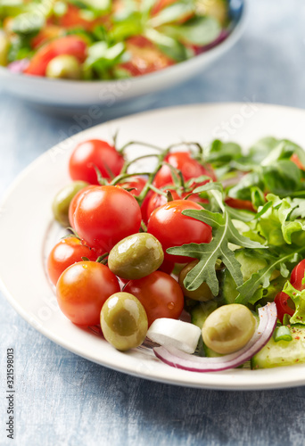 Healthy salad with green olives, cherry tomatoes and rocket. Close up.