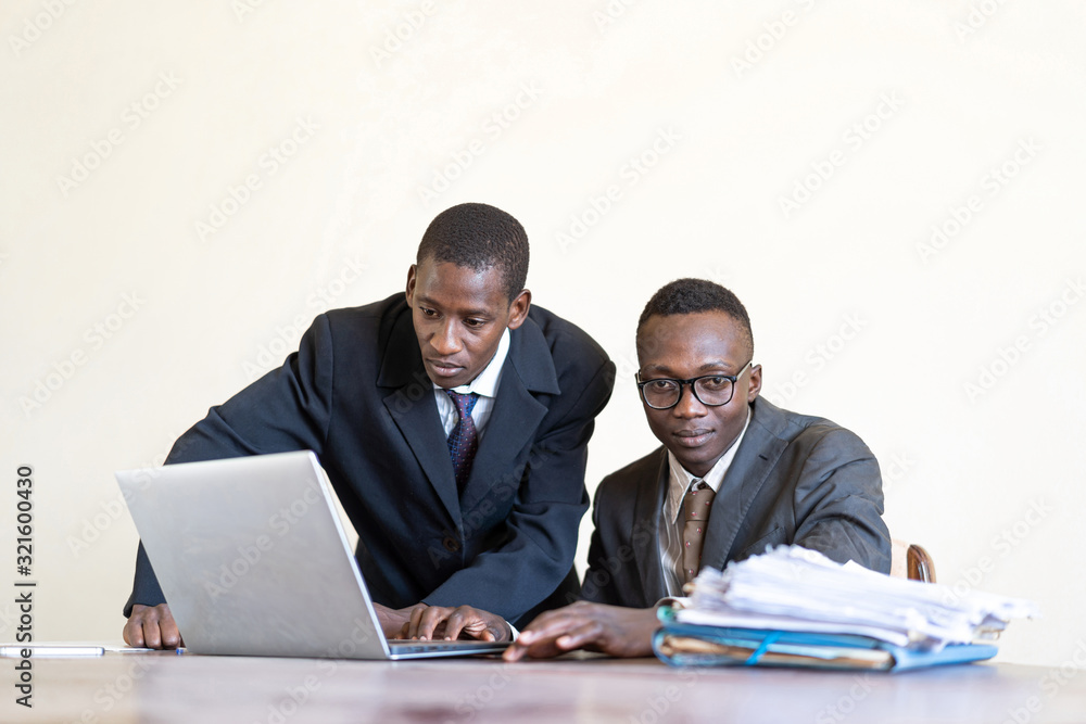 Candid shot of couple of Malian businessmen working together with laptop Candid shot of couple of Malian businessmen working together with laptop