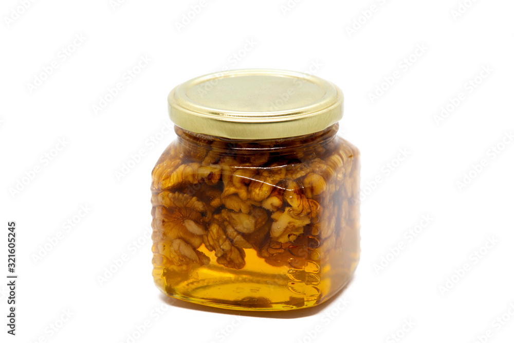 Glass jar with honey and walnuts on white background Glass jar with honey and walnuts on white background