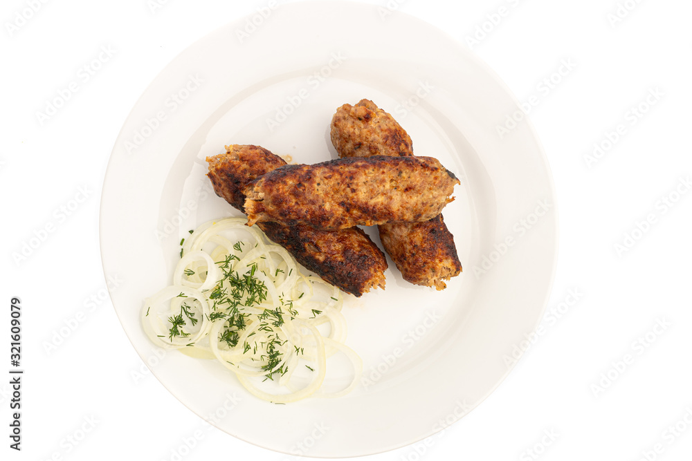 baked on a skewer grill meat long cutlet on a white plate with onions and herbs isolated baked on a skewer grill meat long cutlet on a white plate with onions and herbs isolated