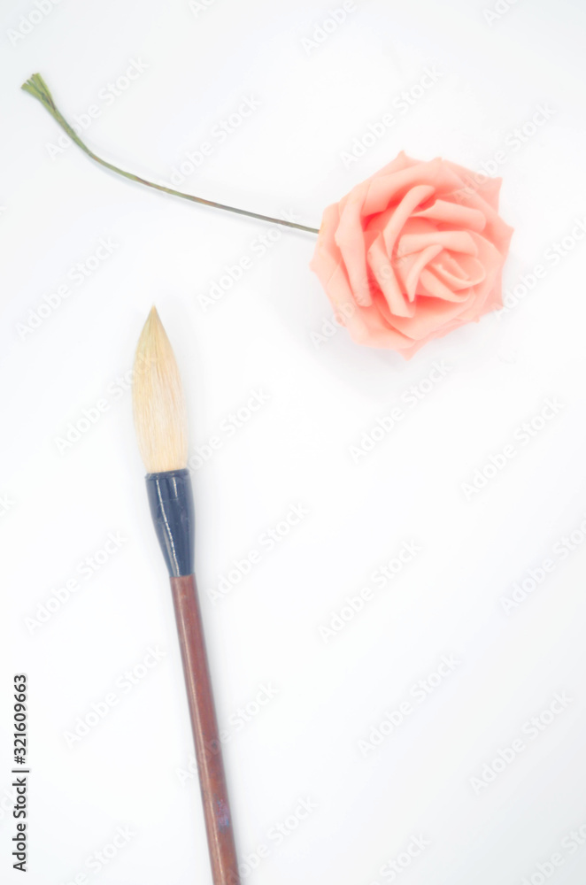 Pink roses and an inkless brush on a white background Pink roses and an inkless brush on a white background