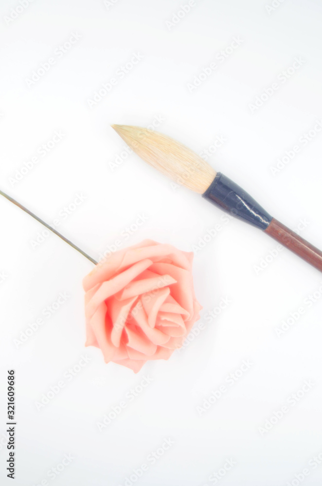 Pink roses and an inkless brush on a white background Pink roses and an inkless brush on a white background