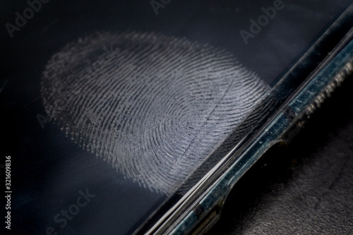 Close-up of realistic dirty glossy smart phone electronics device screen with fingerprint residue above in-screen reader