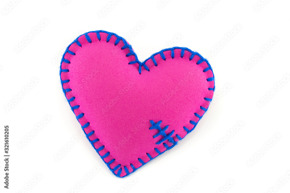 Handmade pink stitched toy heart on white