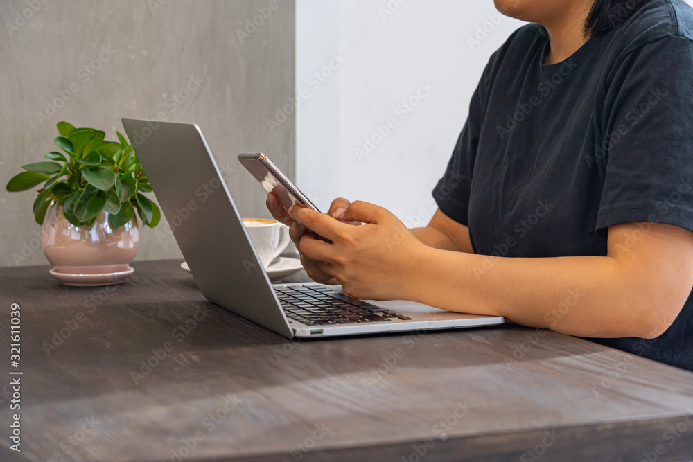 Fototapeta premium Close up photo of woman using smartphone and laptop