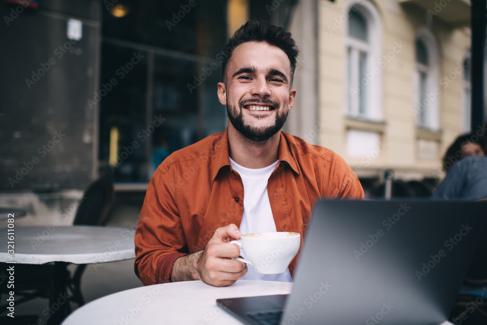 Laughing guy drinking coffee in street cafe Laughing guy drinking coffee in street cafe