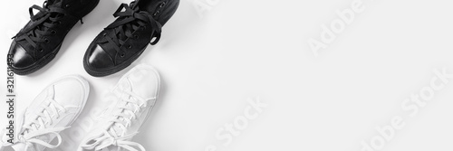 Short white and black low brigt sneakers on the white background.	Banner photo