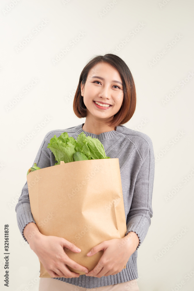 Young woman with a grocery shopping bag. Isolated on white background. Young woman with a grocery shopping bag. Isolated on white background.