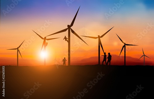Silhouette of engineer and Maintenance team working Maintenance of wind turbines is a clean energy that is widely used today. over blurred background sunset for industry background with Light fair.
