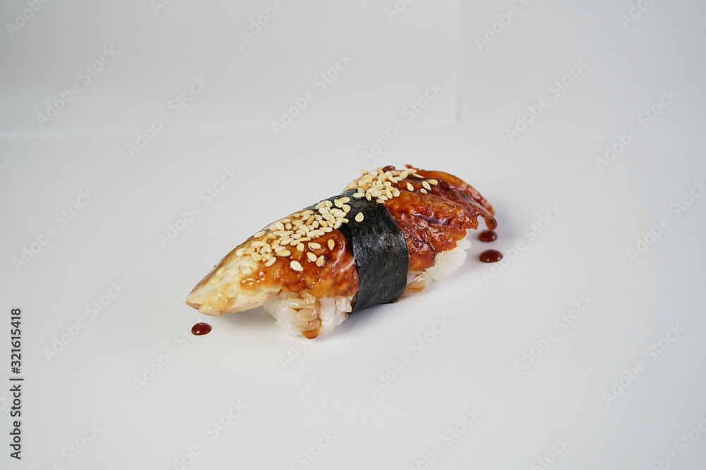 unagi sprinkled with sesame seeds and drizzled with sauce on a white clean background unagi sprinkled with sesame seeds and drizzled with sauce on a white clean background