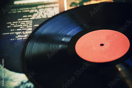 Canvas Print An old vintage black vinyl record lies on the cover of a music album with the playlist's text on it