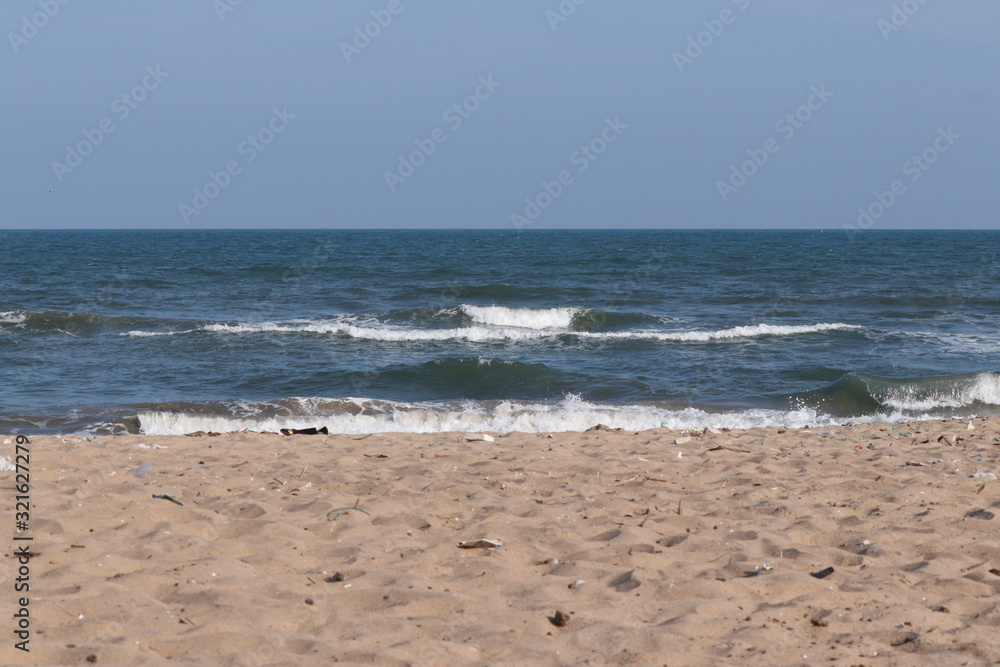 landscape image of coastline on blue sea and clear blue sky with human foots marks on the beach backgrounds