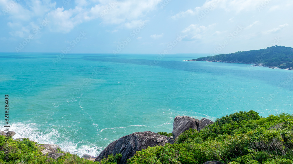 Fototapeta premium Rocky rock over beautiful clear sea and island, view from Kho Phangan, Thailand