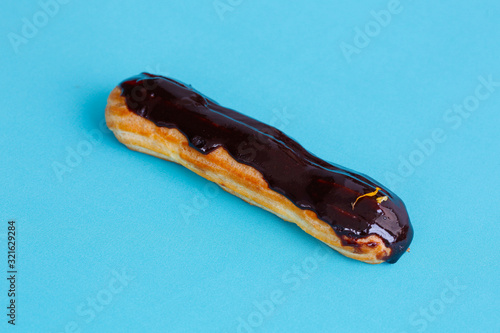 Eclair with chocolate on a blue background