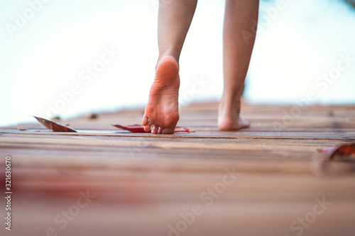 barefoot girl with walking on the bridge wood with blur background outdoor nature