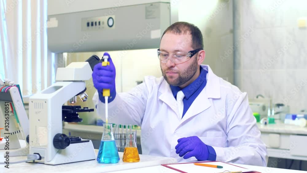 Chemist. A scientist conducts experiments in a scientific laboratory. Performs research using a microscope. Eureka. Victory. New discovery. Happy scientist. Chemist. A scientist conducts experiments in a scientific laboratory. Performs research using a microscope. Eureka. Victory. New discovery. Happy scientist.