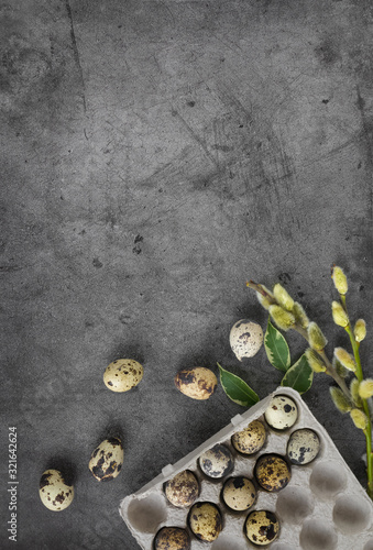 Happy Easter quail eggs in a box on a dark stone background with green leaves and willow branches.Banner, Billboard or greeting card.Easter sale in the store.minimalism.Zero Waste.copyspace