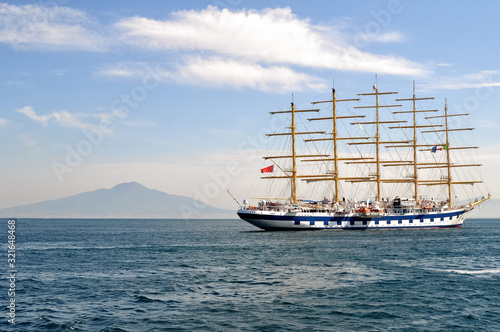 Clipper ship in the sea on mountain range background 